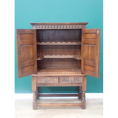 304 - An oak Cupboard on stand in the 17th Century style fitted pair of carved panel doors beneath nulled ... 