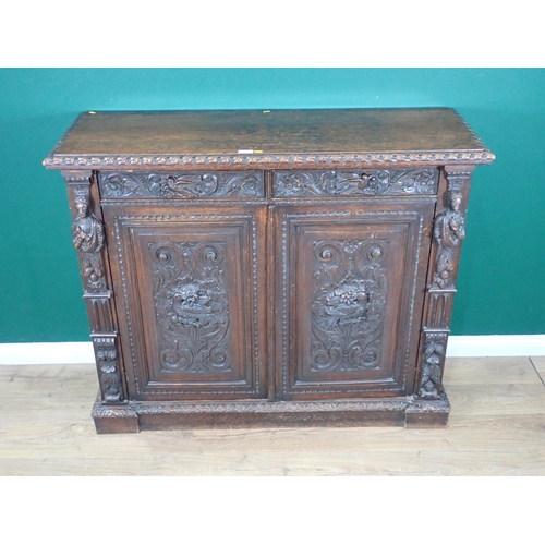 44 - A Victorian carved oak two door Cupboard fitted two frieze drawers above pair of cupboard doors deco... 