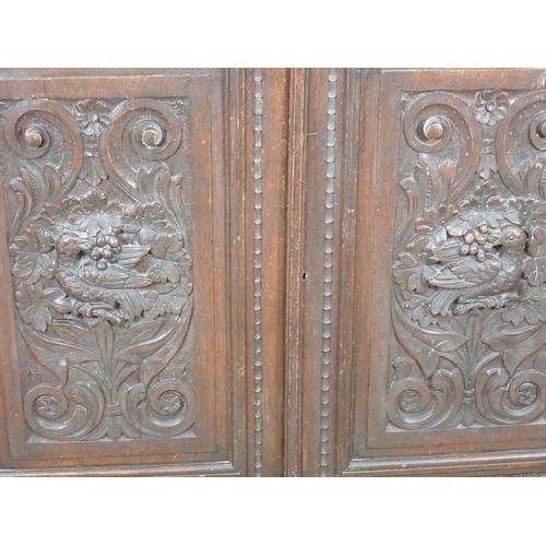 44 - A Victorian carved oak two door Cupboard fitted two frieze drawers above pair of cupboard doors deco... 