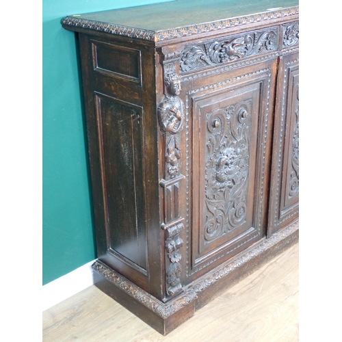 44 - A Victorian carved oak two door Cupboard fitted two frieze drawers above pair of cupboard doors deco... 