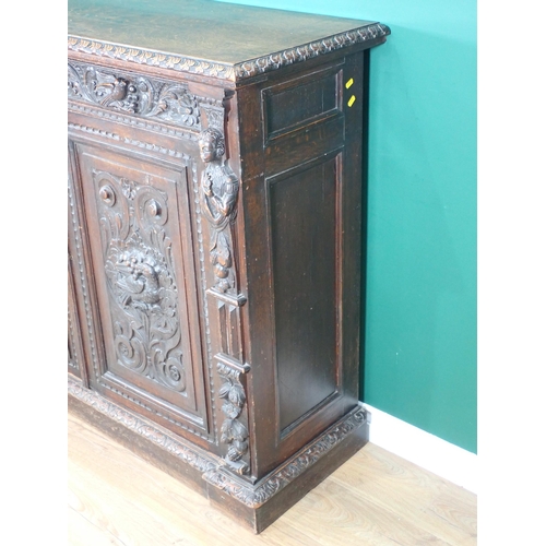 44 - A Victorian carved oak two door Cupboard fitted two frieze drawers above pair of cupboard doors deco... 