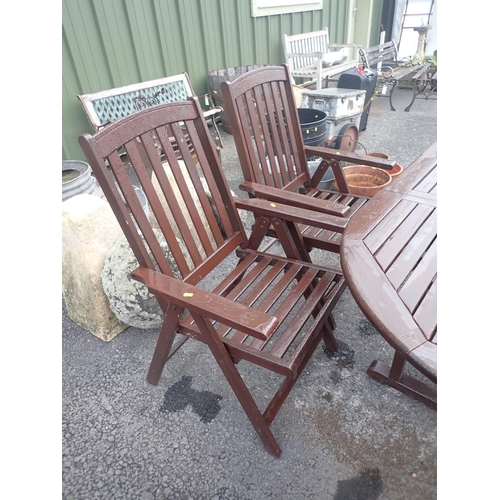 556 - A brown stained Garden Table and two garden Armchairs