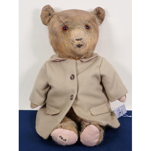 66 - An old Teddy Bear wearing a beige Coat, 21in, pads repaired and worn