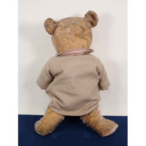 66 - An old Teddy Bear wearing a beige Coat, 21in, pads repaired and worn