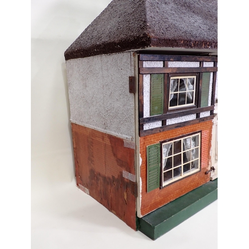 88 - A Doll's House in the style of timber and brick, with hinged doors and containing large large quanti... 