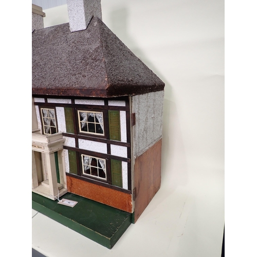 88 - A Doll's House in the style of timber and brick, with hinged doors and containing large large quanti... 