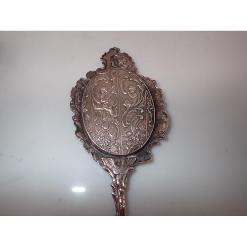 213 - A Continental silver framed small Hand Mirror decorated cherubs playing musical instruments, Import ... 