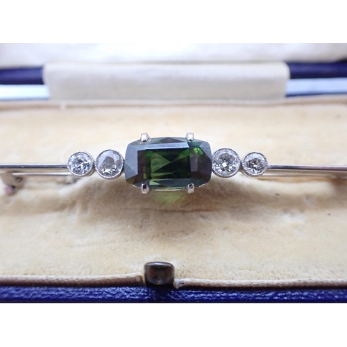 243 - A vintage Bar Brooch claw-set mixed-cut rectangular green stone (possibly garnet) between two pairs ... 