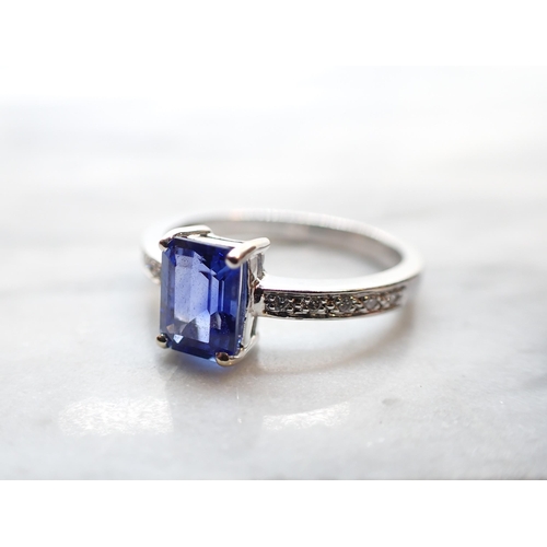 244 - A  Sapphire and Diamond Ring corner claw-set step-cut sapphire, 1.53cts, between pavé-set brilliant-... 