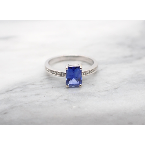 244 - A  Sapphire and Diamond Ring corner claw-set step-cut sapphire, 1.53cts, between pavé-set brilliant-... 