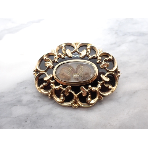 245 - A Victorian Mourning Brooch with central oval hair picture within black enamel and gold frame, inscr... 