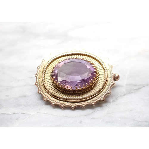 262 - An Amethyst Brooch claw-set oval-cut stone within beaded and scalloped frame in 9ct gold, approx 28m... 