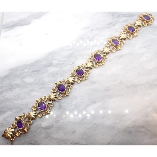 264 - An Amethyst Bracelet comprised of eight openwork scrolled links each set oval-cut stone in 9ct gold,... 