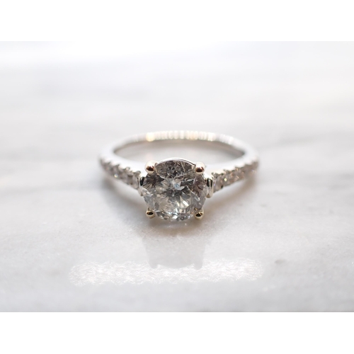 271 - A Diamond single stone Ring claw-set brilliant-cut stone, 1ct,   between graduated brilliant-cut sto... 