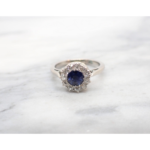 282 - A Sapphire and Diamond Cluster Ring claw-set round sapphire within frame of eleven old-cut diamonds ... 