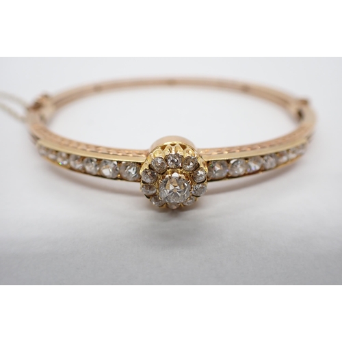 296 - A Diamond hinged Bangle the front claw-set cluster of old-cut stones between rows of graduated stone... 