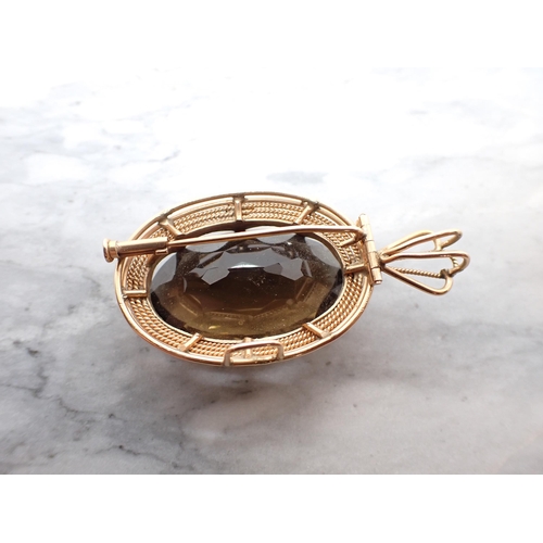 312 - A Smoky Quartz Pendant/Brooch claw-set large oval-cut stone in rose gold rope twist frame with folda... 