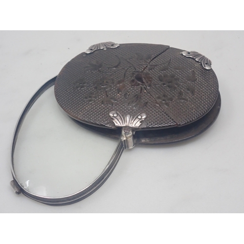 354 - A 19th Century pressed tortoiseshell oval Magnifying Glass with floral carved decoration and white m... 