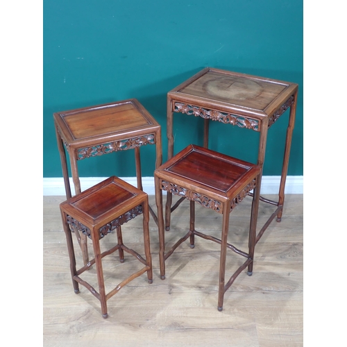 387 - A nest of four Oriental Occasional Tables with inset tops, carved leaf and fruiting decorated pierce... 