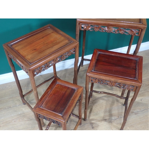 387 - A nest of four Oriental Occasional Tables with inset tops, carved leaf and fruiting decorated pierce... 