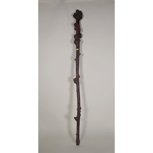 396 - An Oriental carved faux bamboo stick, carved sage to the handle, 3ft 11in L