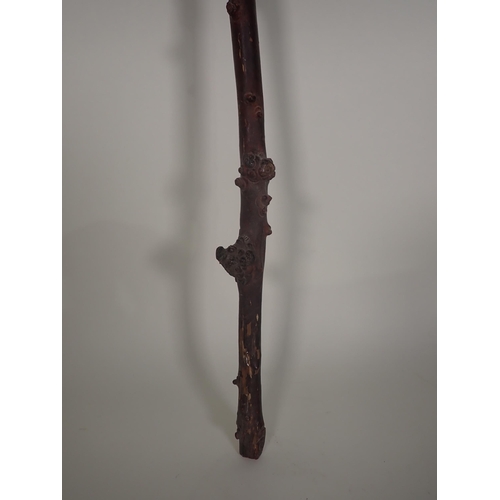 396 - An Oriental carved faux bamboo stick, carved sage to the handle, 3ft 11in L