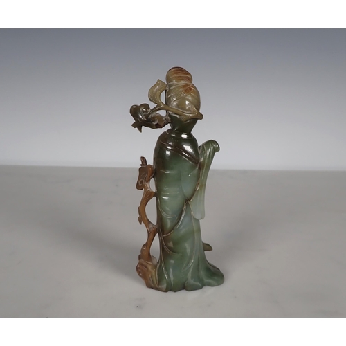 407 - An Oriental carved jade standing figure of Chinese Lady wearing robes having branch and leaf applied... 