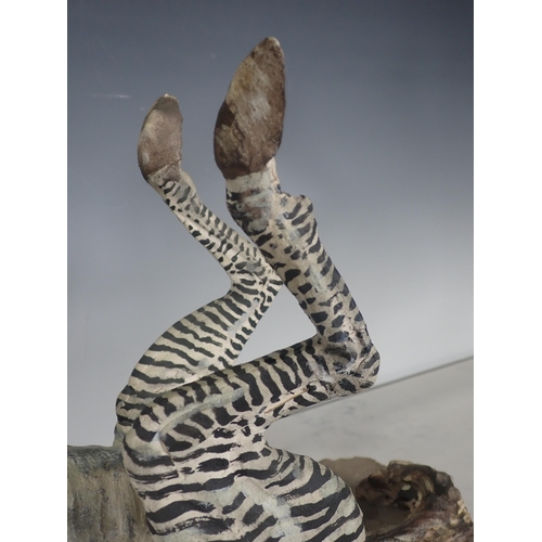 451 - PIERRE DIAMANTOPOULO. A stoneware Model of a Zebra lying on its back, and mounted on a stone plinth,... 