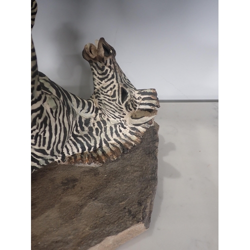 451 - PIERRE DIAMANTOPOULO. A stoneware Model of a Zebra lying on its back, and mounted on a stone plinth,... 