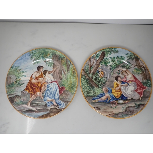 455 - A pair of Italian Maiolica Plates, painted romantic couples in landscapes 'Rinaldo and Armida' and '... 