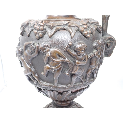 463 - A pair of bronze pedestal Ewers in the classical style with cherub heads to the scroll handles and e... 