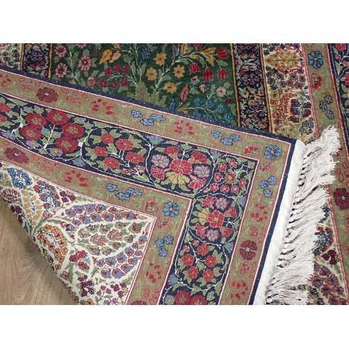 500 - A fine quality Persian Rug with floral designs two the borders, and central oval depicting vase of f... 