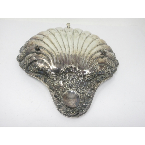 52 - A Victorian silver scallop shape Dish with floral and scroll design raised on three shell feet, Shef... 