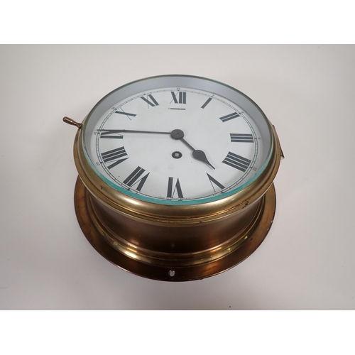 526 - A brass cased circular Clock with white enamel dial, having single train movement, 10in diam