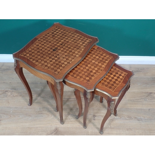 573 - A nest of three French Tables with shaped rectangular tops having parquetry inlay and edged in brass... 