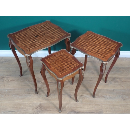 573 - A nest of three French Tables with shaped rectangular tops having parquetry inlay and edged in brass... 