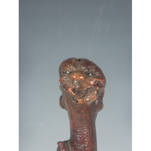 589 - A burr wood Stick carved grotesque masks on a marble plinth, 16½in H overall