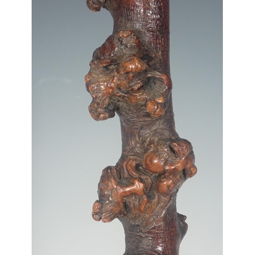 589 - A burr wood Stick carved grotesque masks on a marble plinth, 16½in H overall