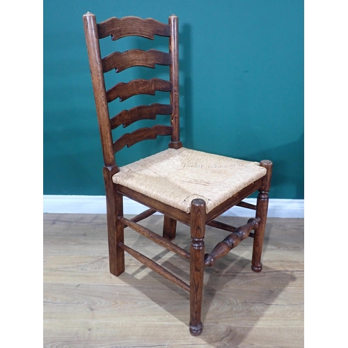 595 - A set of six oak ladderback Dining Chairs with rush seats on turned supports and stretchers; two car... 