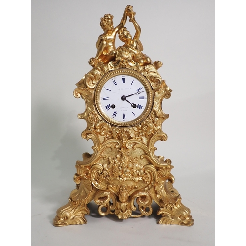 599 - A 19th Century French gilded metal Mantel Clock by Le Roy & Fils with white enamel dial surmounted b... 