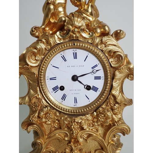 599 - A 19th Century French gilded metal Mantel Clock by Le Roy & Fils with white enamel dial surmounted b... 