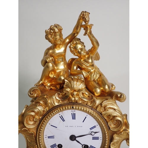 599 - A 19th Century French gilded metal Mantel Clock by Le Roy & Fils with white enamel dial surmounted b... 