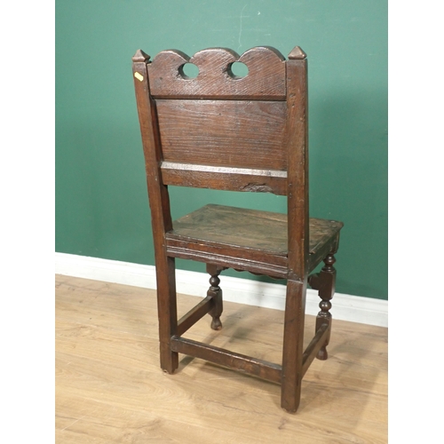 604 - A 17th Century oak Hall Chair with pierced and carved top rail, panelled back and raised on squared ... 