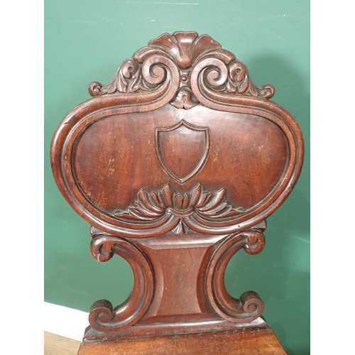 651 - A pair of 19th Century mahogany Hall Chairs with carved and shaped backs and raised on reeded taperi... 