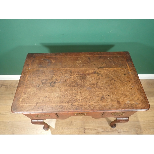 736 - An 18th Century oak Lowboy with moulded and feather banded top above three drawers and shaped frieze... 