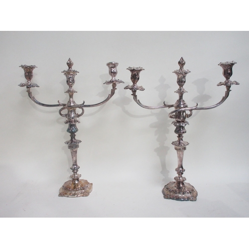 79 - A pair of plated two branch three light Candlesticks with foliate bands on shaped circular bases, 21... 