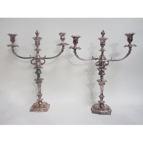 79 - A pair of plated two branch three light Candlesticks with foliate bands on shaped circular bases, 21... 