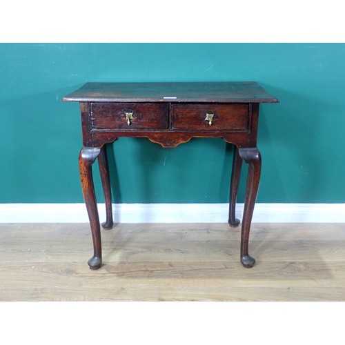 712 - A Georgian oak Lowboy, the moulded top over two drawers with brass drop handles and raised on tapere... 