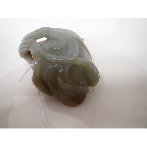 404 - An Oriental jade lotus blossom Bowl with carved leafage design on a hardwood stand, 4 in long