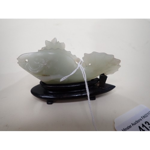 413 - A Chinese celadon Jade carved Fish with lily pad and flower to one side, small chips, on hardwood st... 